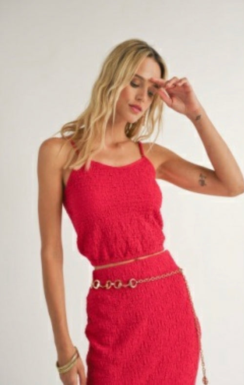Sadie and Sage model posing with On The Pier Knit Tank Top, red knit top with spaghetti straps and gathered at waist. She is also wearing a red skirt and silver chain belt. 